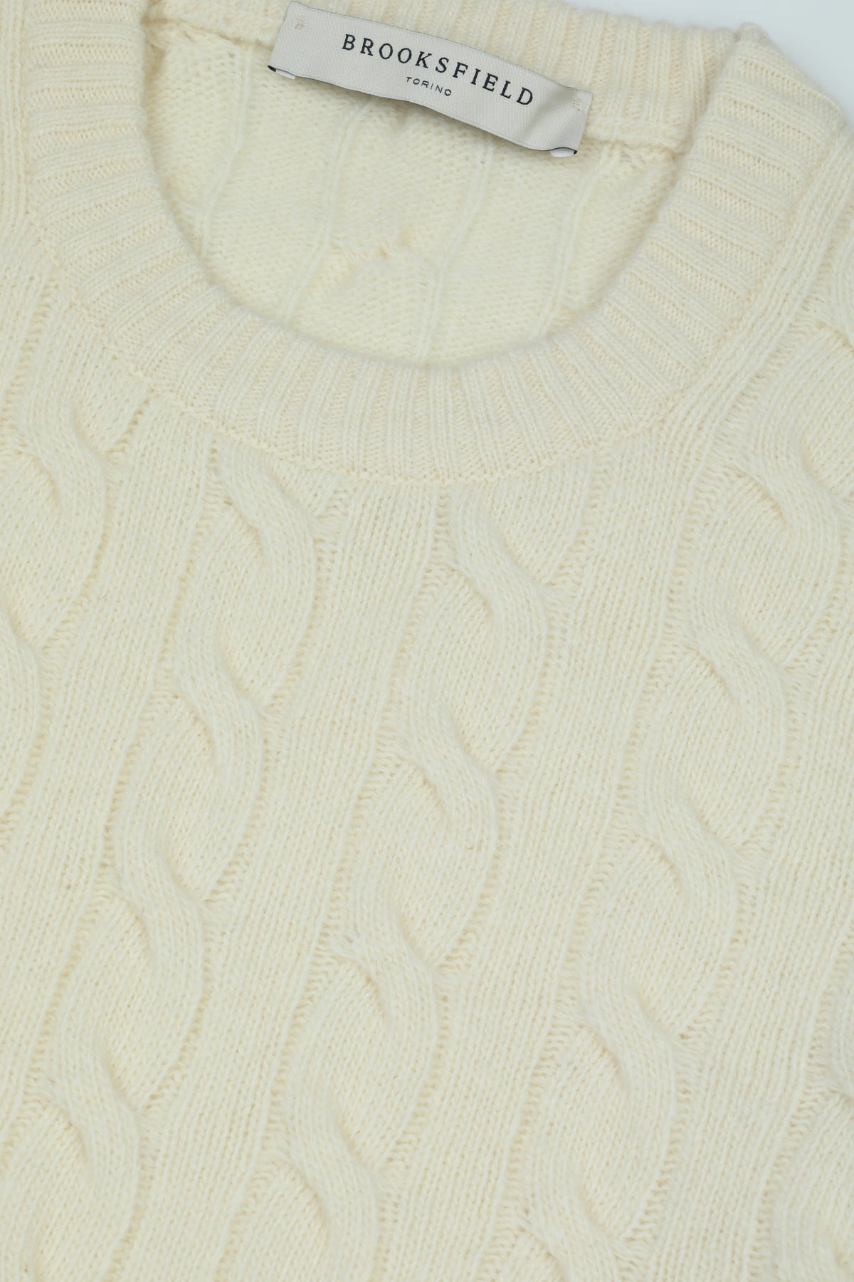 Maglia girocollo realizzata in lana vergine e lavorata a punto trecce. Panna - Latte