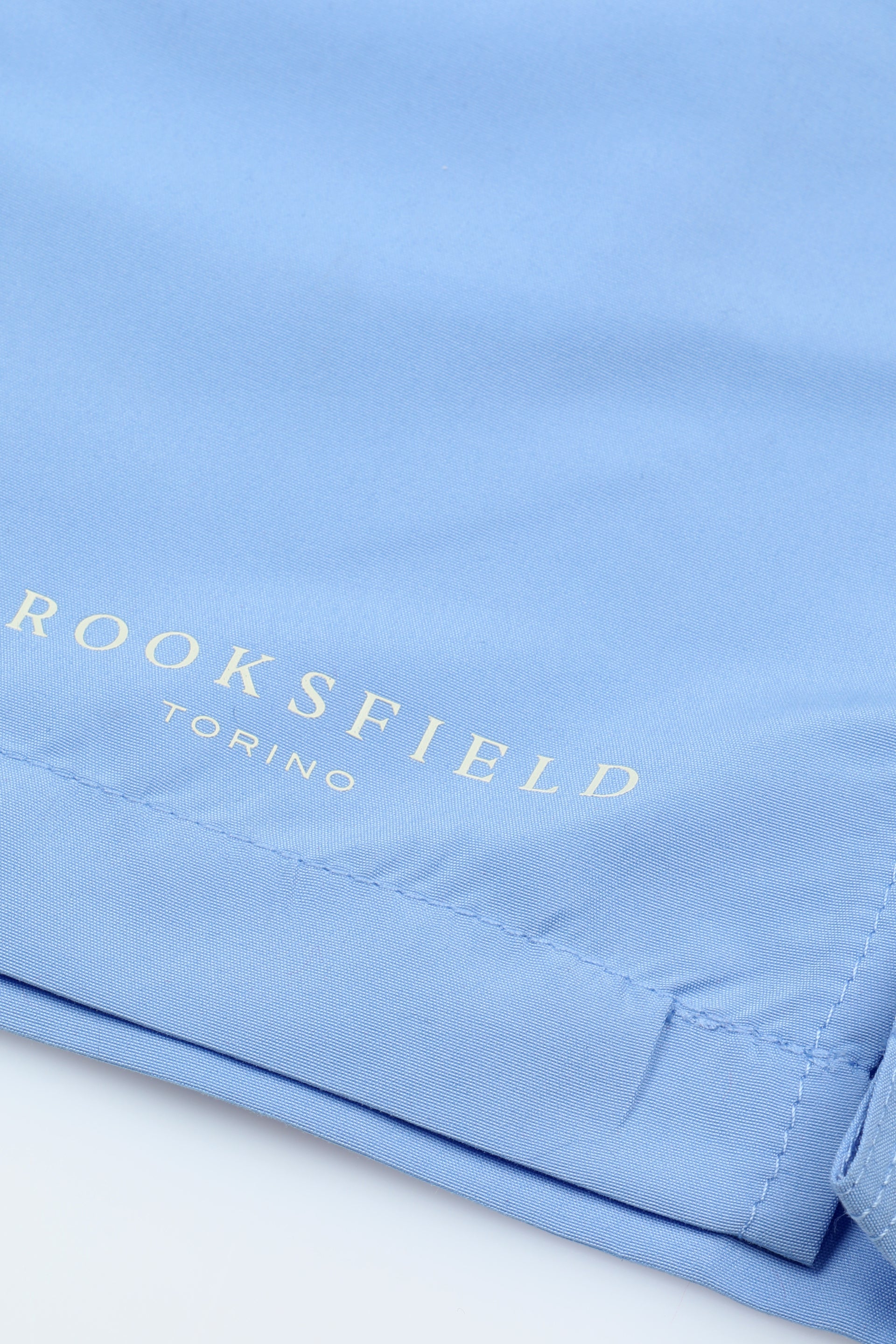 UOMO-BOXER MARE IN MICROFIBRA TINTA UNITA, TASCHE LATERALI, TASCHINO CON ALETTA APPLICATO DIETRO, ELASTICO E COULISSE IN VITA, STAMPA MARCHIO SU GAMBA - Sky blue